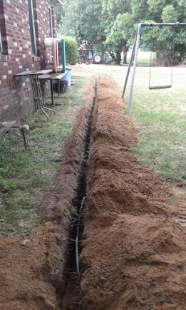 Freshly excavated sewer line trench across a Yonkers backyard