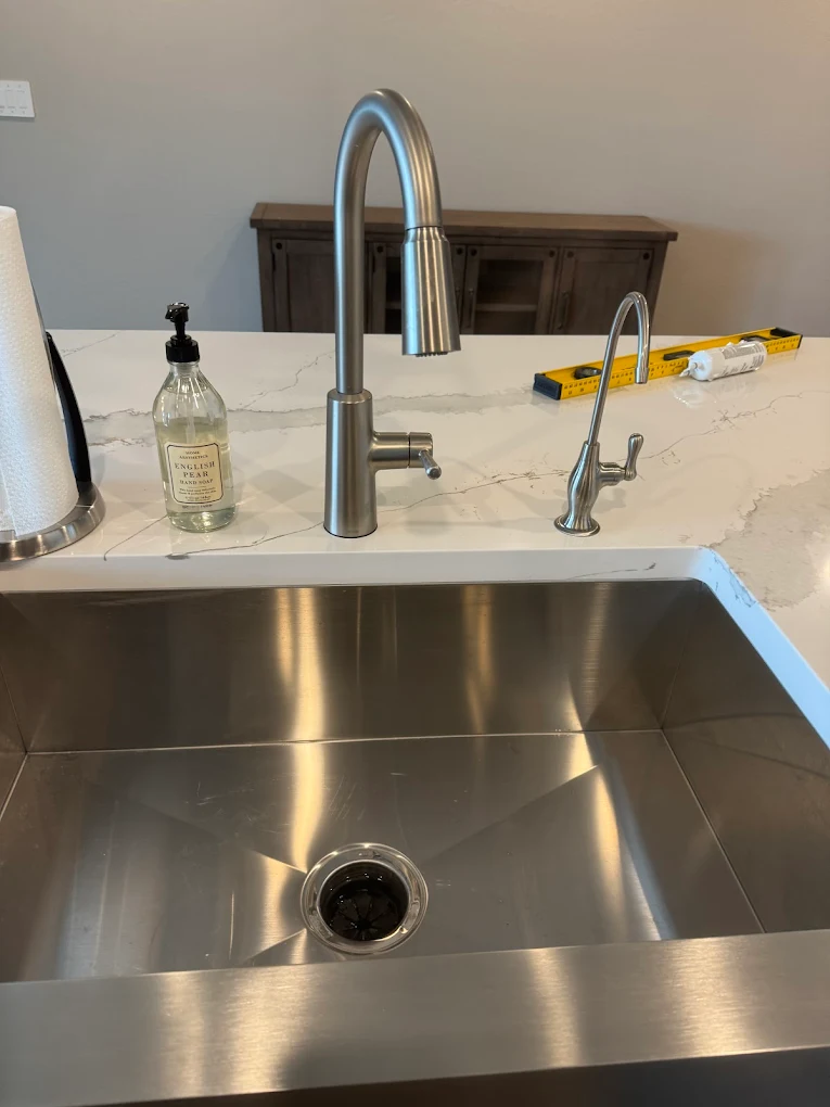 Stainless single-bowl undermount sink with brushed nickel pull-down faucet on quartz countertop
